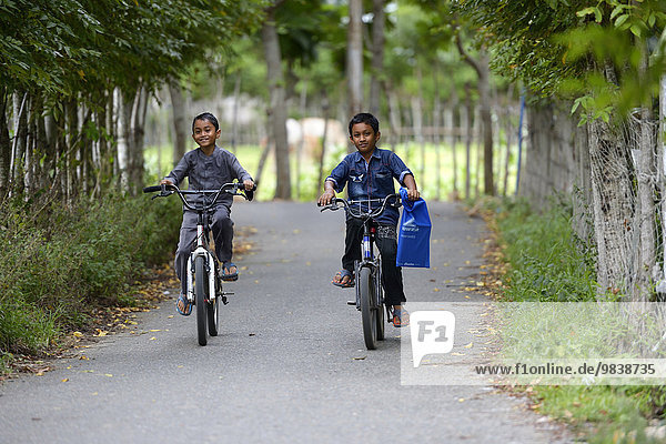 Two boys on bicycles  Lam village Teungo  Aceh  Sumatra  Indonesia  Asia