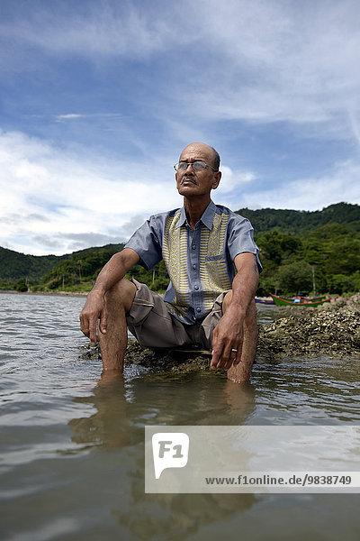 Alter Mann blickt auf das Meer dem beim Tsunami 2004 fast seine gesamte Familie zum Opfer gefallen ist Dorf Lam Rukam Subdistrict Rozma Aceh Sumatra Indonesien Asien