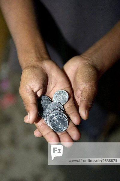 Panhandled money in the hands of a street child  Cochabamba  Bolivia  South America