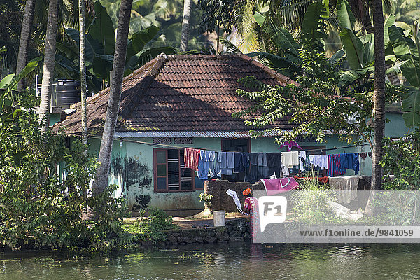 Frau wäscht Wäsche an einem Kanal  Kanalsystem Backwaters  Champakulam  Kerala  Indien  Asien