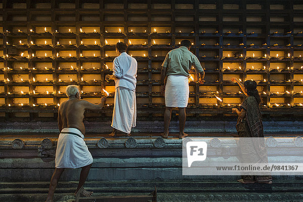 Öllämpchen für hinduistische Feuerzeremonie Aarti werden in Nischen an der Außenwand des Tempels entzündet  Ambalapuzha  Kerala  Indien  Asien