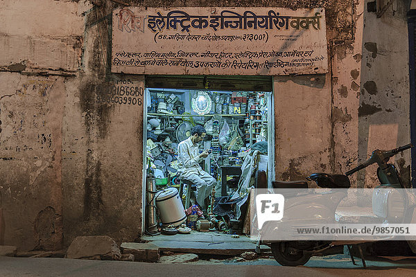 Elektrohändler in seiner Werkstatt am Abend  Udaipur  Rajasthan  Indien  Asien