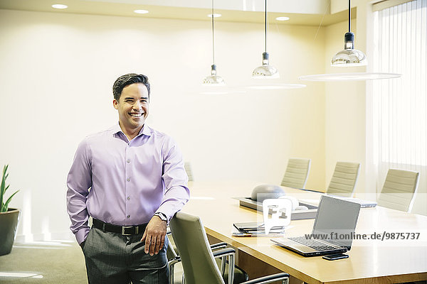 Mixed race businessman smiling in conference room