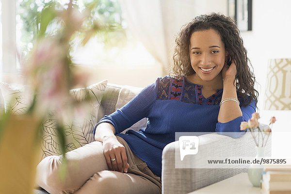 Mixed race woman smiling on sofa