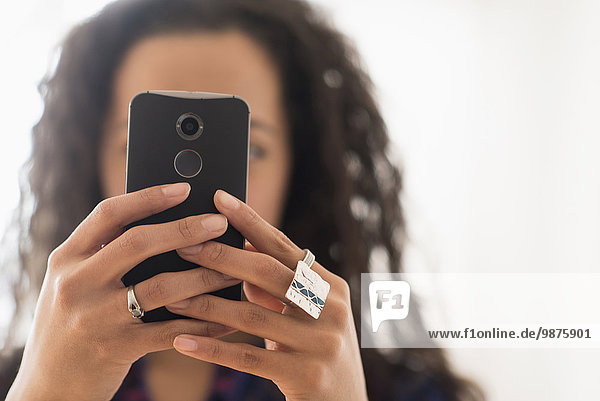 Close up of mixed race woman using cell phone