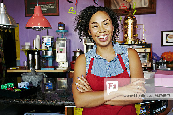 Mixed race barista smiling in coffee shop