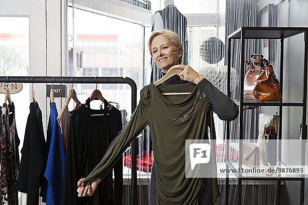 Older Caucasian woman shopping in clothing store