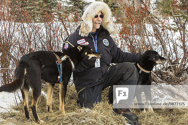 Volunteer veterinarian  Jay Butan  poses for photos with dropped dogs at the Rainy Pass checkpoint during Iditarod 2014  Southcentral Alaska