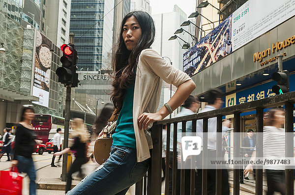 'Chinese young woman in a busy  urban centre; Hong Kong  China'