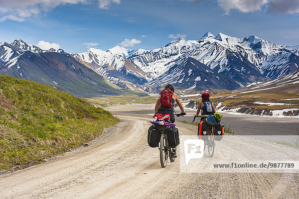 Two women bicycle touring in Denali National Park  Grassy Pass  Interior Alaska