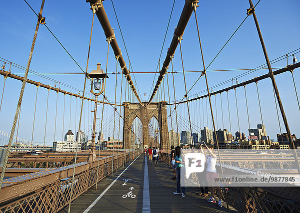 'Tourists taking photographs on Brooklyn Bridge; New York City  New York  United States of America'