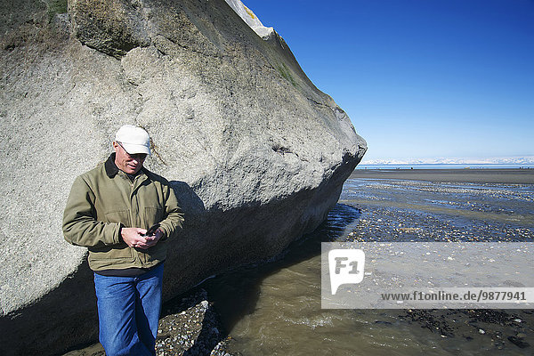 Handy Felsbrocken stehend benutzen Mann Anordnung groß großes großer große großen Kenai-Fjords-Nationalpark Kenai-Halbinsel
