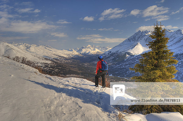Man Snowshoeing Above Arctic Valley With Chugach Mountains In The Background  Southcentral Alaska
