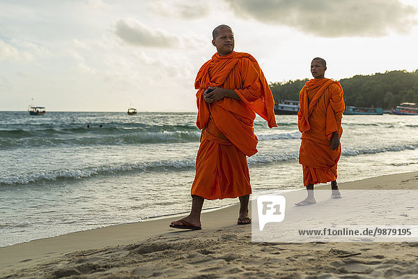 'Monks walking on the sand of Serendipity Beach; Sihanoukville  Cambodia'