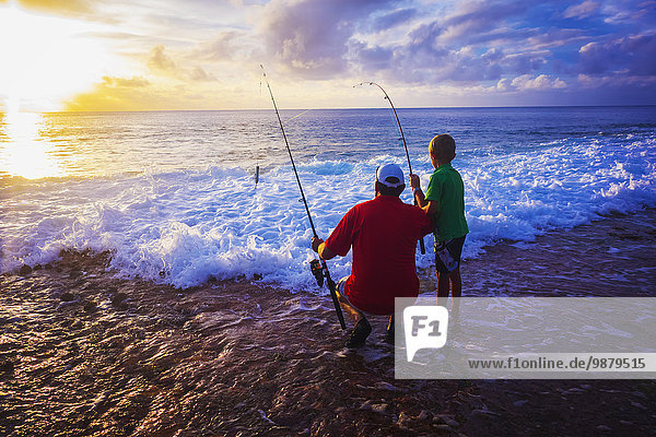 'Father and son fishing on Niue Island; Niue'