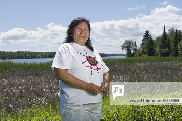 Middle Aged Native American Woman Standing In A Lakeside Field In Shoal Lake  Ontario  Canada