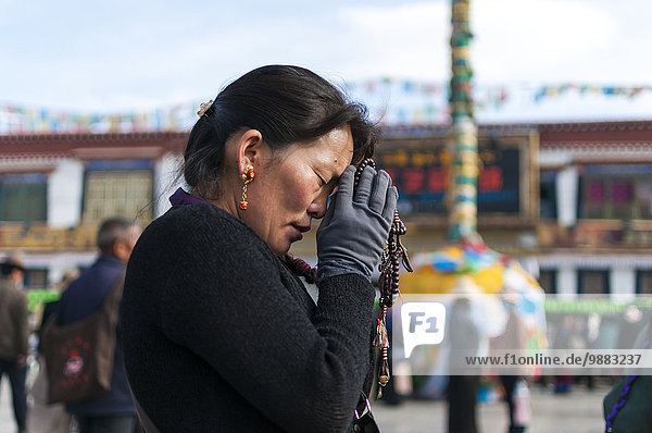'A woman prays in front of Jokhang Temple; Lhasa  Tibet  China'