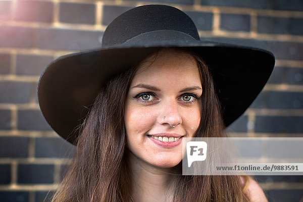 Portrait of young woman with hat and nose ring stud