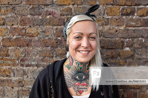 Portrait einer jungen Frau mit Nasenring und Tattoo