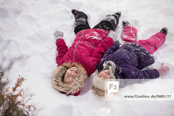 Schwestern spielen draußen im Schnee