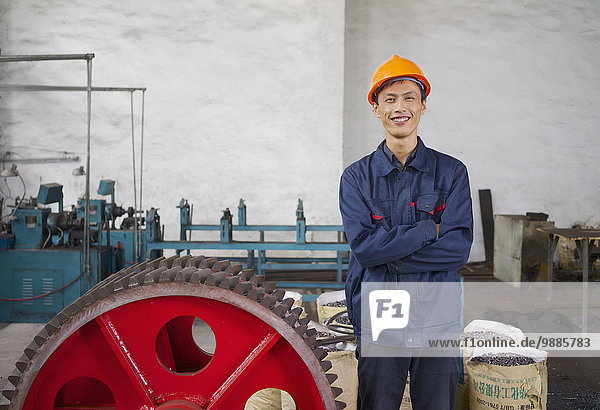 Portrait des Arbeiters neben dem Zahnrad in der Kranfabrik  Provinz Jiangsu  China