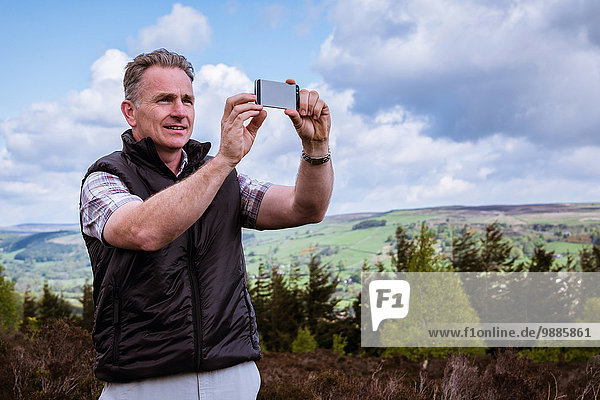 Männliche Wanderer fotografieren mit Smartphone auf Heidemoor  Pateley Bridge  Nidderdale  Yorkshire Dales