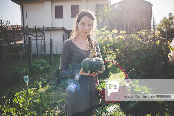 Young woman holding homegrown squash