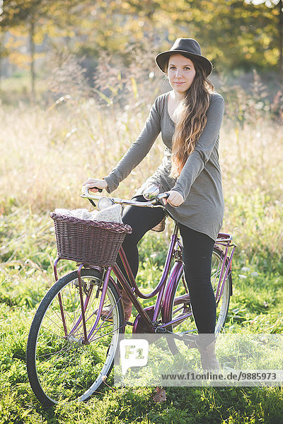 Junge Frau mit Hut auf dem Fahrrad