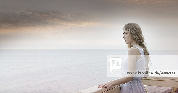 Young woman gazing out to sea from balcony  Miami Beach  Florida  USA