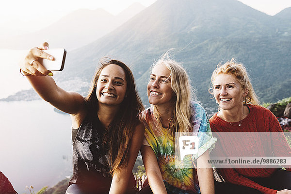 Three female friends taking smartphone selfie at Lake Atitlan  Guatemala