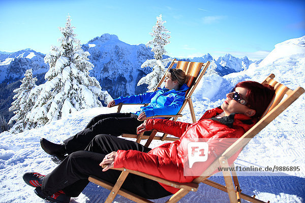 Two women in lounger in snow  Tegelberg  Ammergau Alps  Allgaeu  Bavaria  Germany  Europe