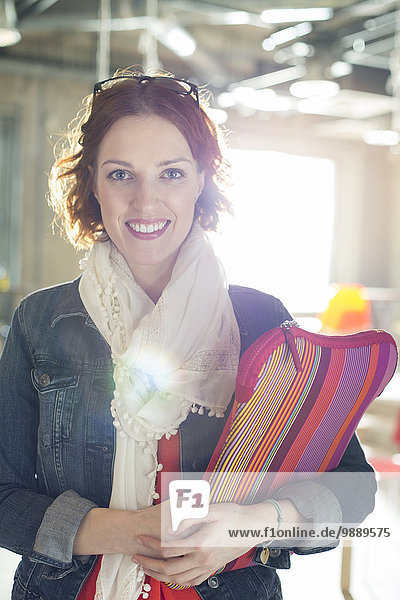 Porträt einer lächelnden Geschäftsfrau mit Laptoptasche