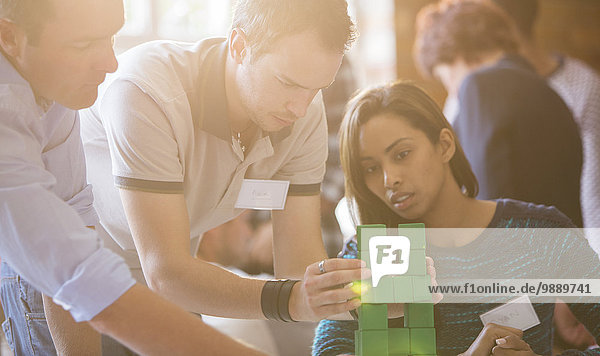 Business people stacking green blocks