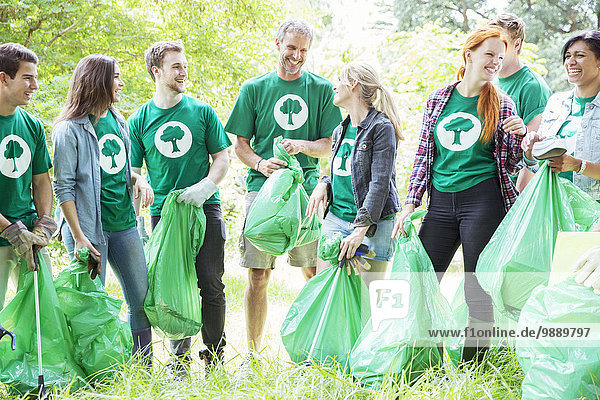 Smiling environmentalist volunteers picking up trash