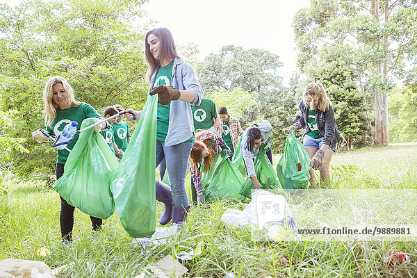 Environmentalist volunteers picking up trash in field