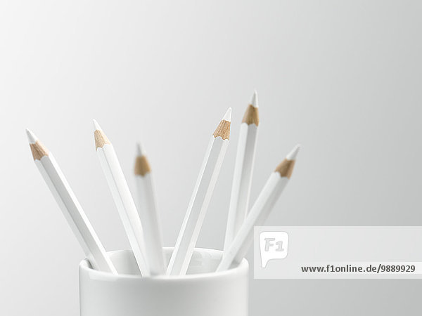 Weiße Bleistifte in weißer Tasse Stilleben
