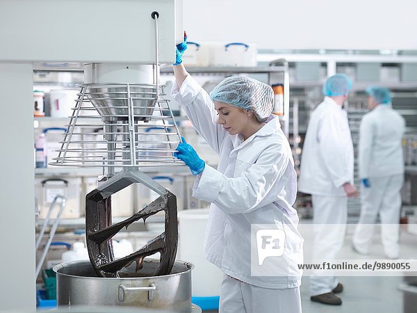Arbeiterin mischt Schokolade in der Kuchenfabrik