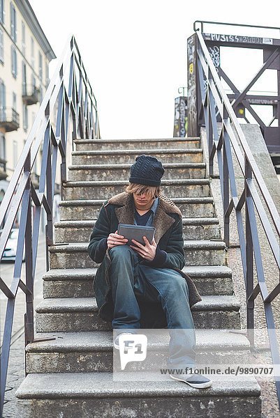 Mann mit digitalem Tablett auf der Treppe  Mailand  Italien