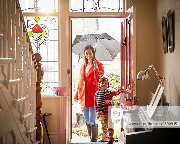 Mutter und Sohn  die an einem regnerischen Tag vor der Haustür ankommen  Porträt