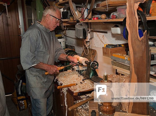Älterer Mann  der mit Schreinerwerkzeugen Holz formt