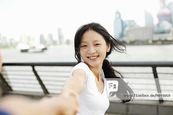 Junge Frau tanzt mit Freund am Wasser  The Bund  Shanghai  China