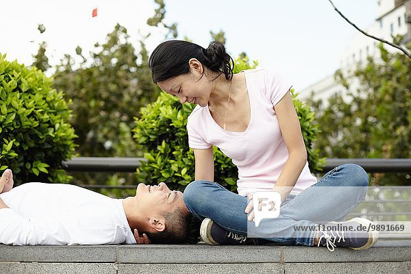 Tourist couple sitting and lying on wall  The Bund  Shanghai  China