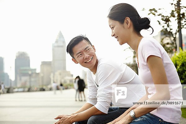 Tourist couple sitting on wall  The Bund  Shanghai  China