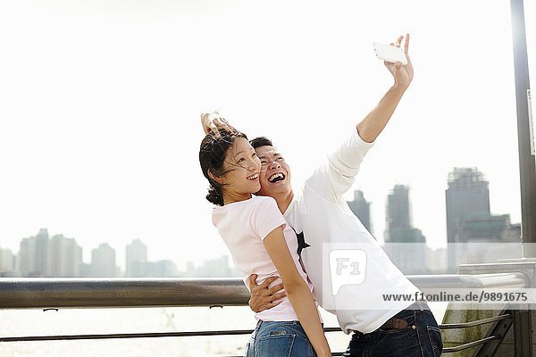 Tourist couple taking smartphone selfie  The Bund  Shanghai  China