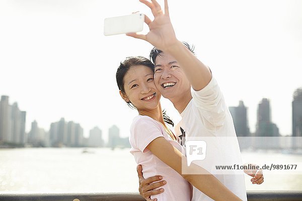 Tourist couple taking smartphone self portrait  The Bund  Shanghai  China