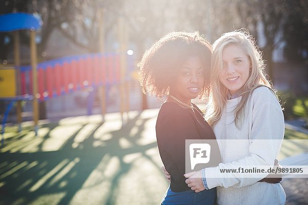 Porträt von zwei Freundinnen  die sich im Park umarmen