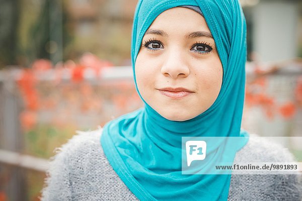 Nahaufnahme des Porträts einer jungen Frau mit türkisfarbenem Hijab