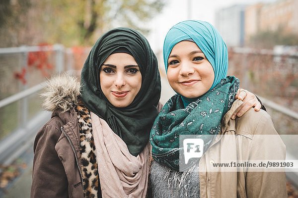 Portrait of two young female friends on park path