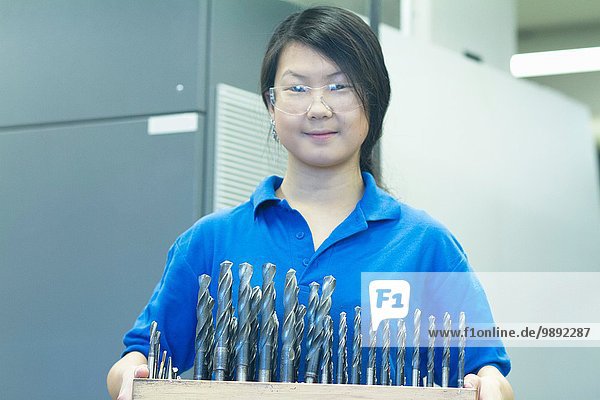 Young woman holding drill bits