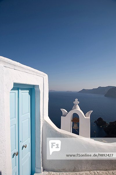 Blick auf blauen Kircheneingang und Glockenturm  Oia  Santorini  Kykladen  Griechenland